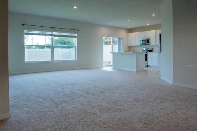 unfurnished living room featuring light colored carpet