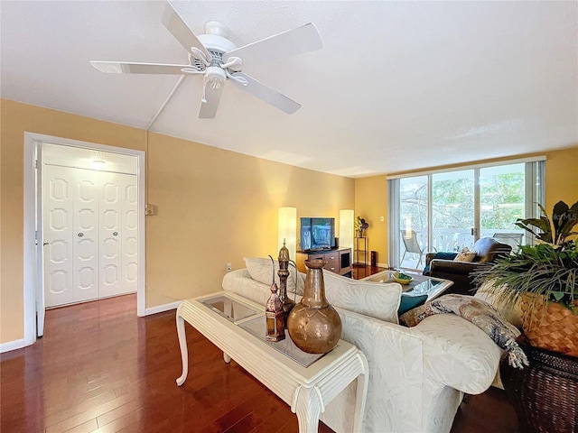 living room with ceiling fan and dark hardwood / wood-style flooring