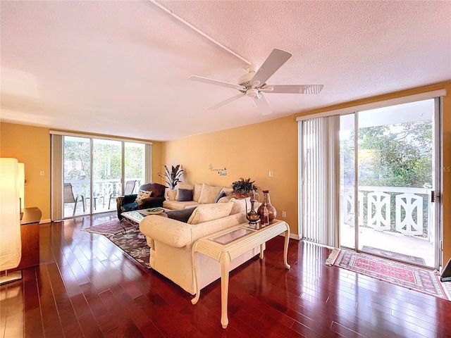 living room with ceiling fan, plenty of natural light, and dark hardwood / wood-style flooring