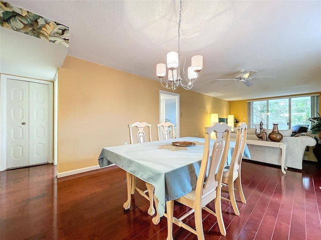 dining space with ceiling fan with notable chandelier, dark wood-type flooring, and a textured ceiling