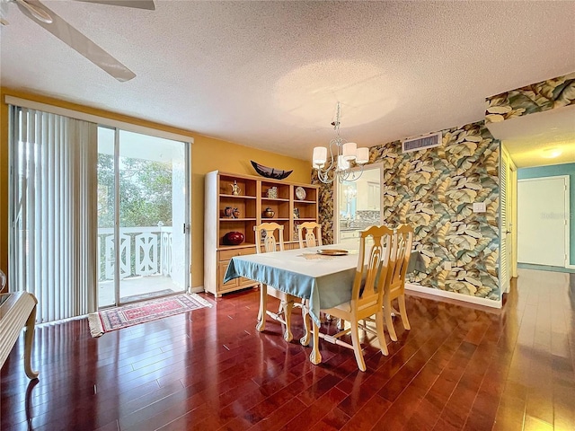 dining space featuring a textured ceiling, dark wood-type flooring, and a chandelier