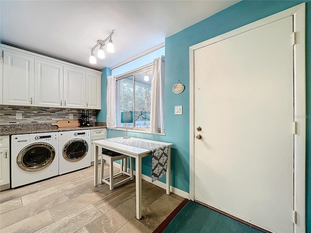 washroom with cabinets, separate washer and dryer, and rail lighting