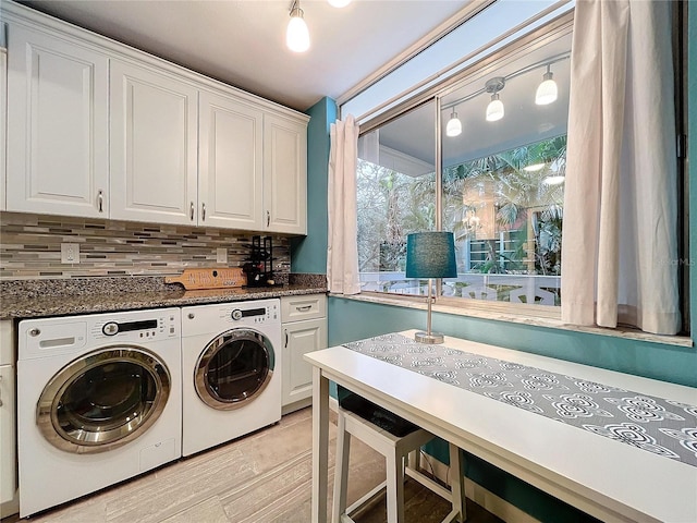 laundry room with light tile patterned floors, cabinets, and washer and clothes dryer