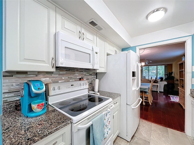 kitchen with white appliances, white cabinets, dark stone counters, and tasteful backsplash