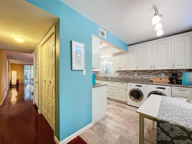 washroom featuring washer and dryer, sink, a wealth of natural light, and a textured ceiling