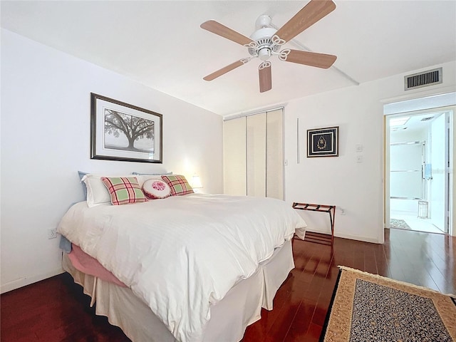 bedroom with ceiling fan, a closet, and dark wood-type flooring