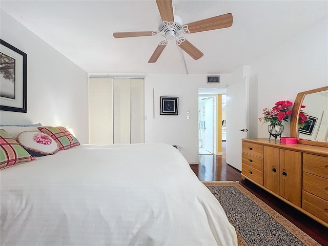 bedroom featuring ceiling fan, a closet, and dark hardwood / wood-style flooring