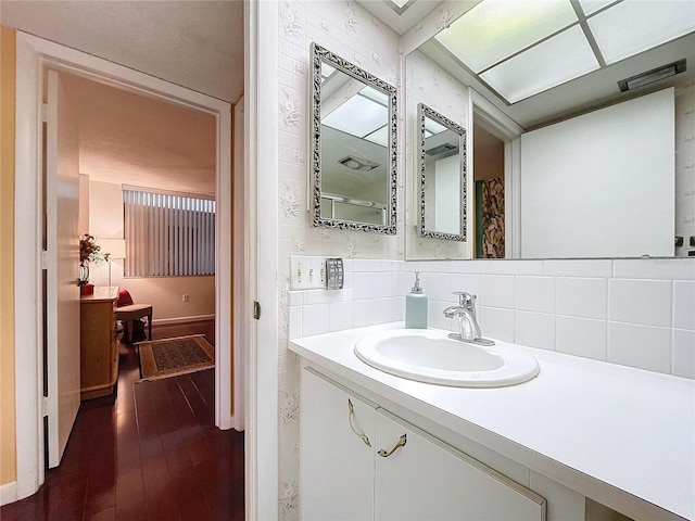 bathroom featuring vanity, backsplash, and hardwood / wood-style flooring