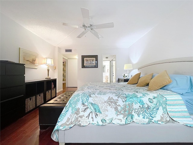 bedroom featuring ceiling fan, dark hardwood / wood-style floors, and a textured ceiling