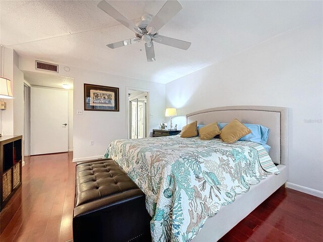 bedroom featuring ceiling fan, a textured ceiling, and dark hardwood / wood-style flooring