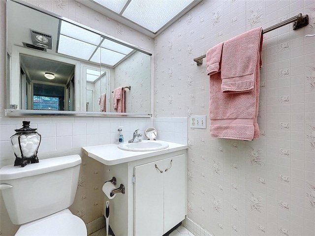 bathroom with toilet, vanity, and backsplash