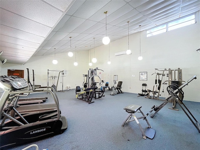 workout area featuring an AC wall unit and a high ceiling