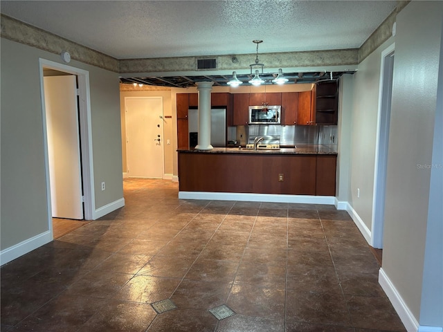 kitchen with sink, hanging light fixtures, stainless steel appliances, a textured ceiling, and kitchen peninsula