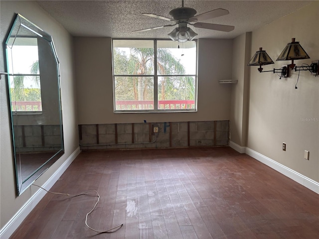 empty room with hardwood / wood-style flooring, a healthy amount of sunlight, and a textured ceiling