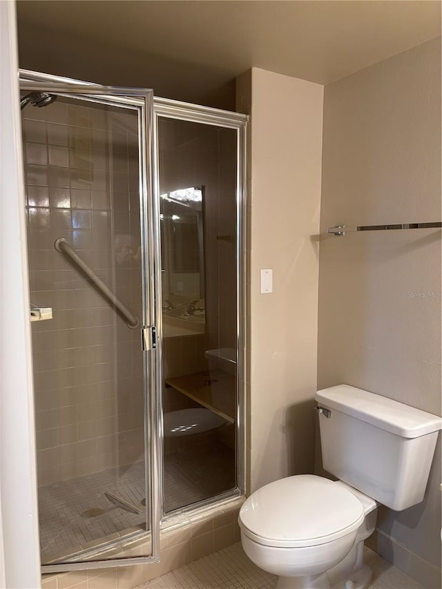 bathroom with a shower with shower door, tile patterned floors, and toilet