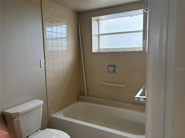 bathroom with toilet and tiled shower / bath combo