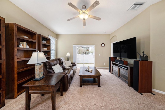 living area featuring light carpet, baseboards, visible vents, and a ceiling fan