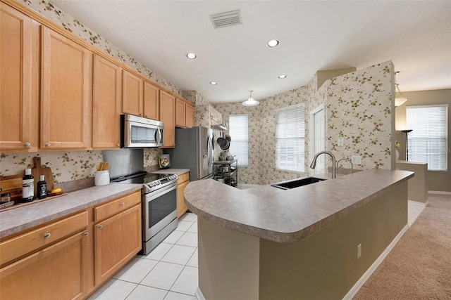 kitchen featuring stainless steel appliances, sink, a center island with sink, and light tile patterned floors