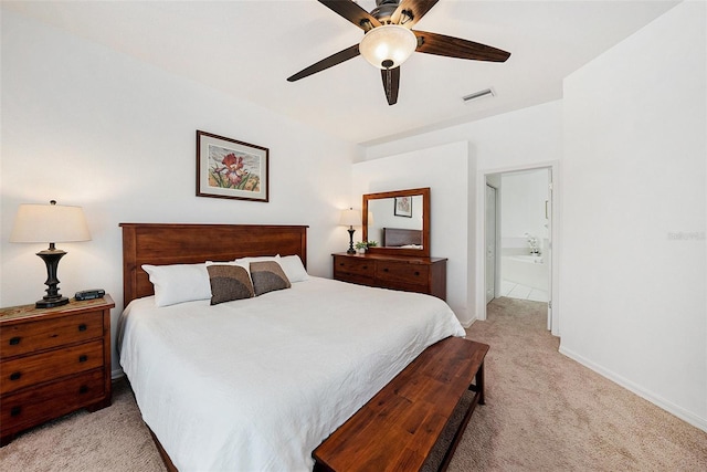 bedroom featuring light carpet, ceiling fan, and ensuite bathroom