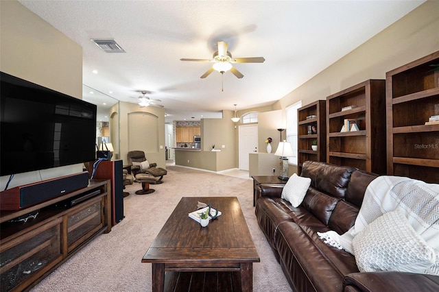 living room featuring light carpet and ceiling fan