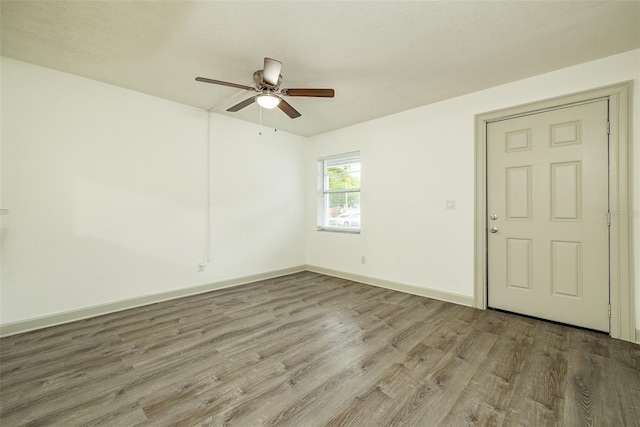 empty room with hardwood / wood-style flooring and ceiling fan