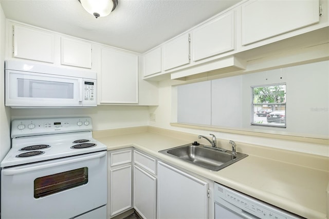 kitchen featuring a textured ceiling, white cabinetry, sink, and white appliances