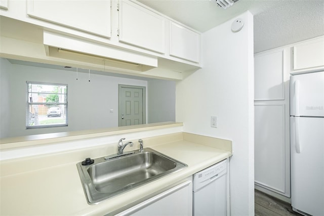 kitchen with dark hardwood / wood-style floors, white appliances, a textured ceiling, white cabinets, and sink