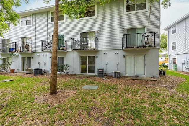 back of house featuring central AC unit and a yard