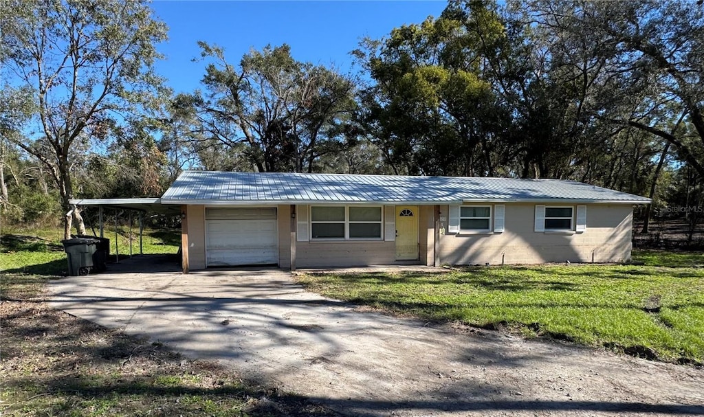 view of front of home featuring a front lawn, a carport, and a garage