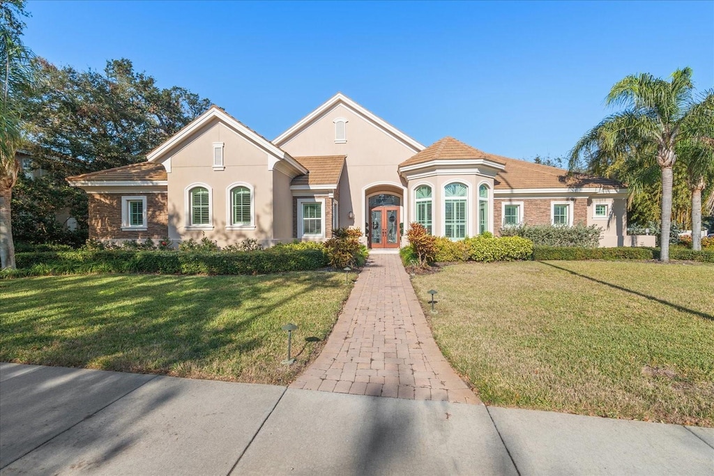 view of front facade with a front yard and french doors