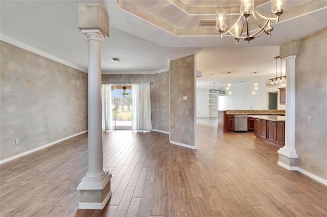 unfurnished living room featuring wood-type flooring and ornate columns