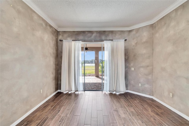 empty room with ornamental molding and a textured ceiling