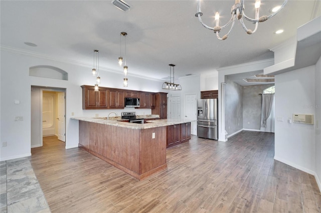 kitchen with light stone countertops, appliances with stainless steel finishes, kitchen peninsula, pendant lighting, and a breakfast bar