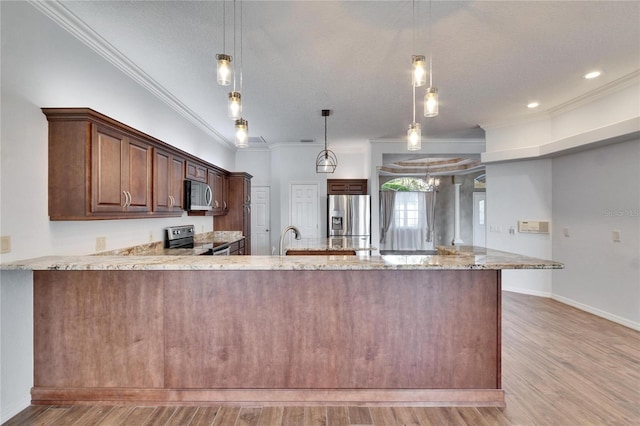 kitchen with stainless steel appliances, light hardwood / wood-style flooring, kitchen peninsula, and decorative light fixtures