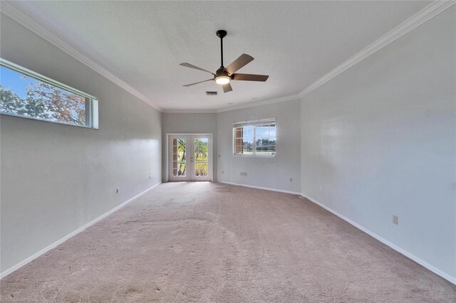 carpeted spare room featuring ceiling fan, french doors, and crown molding