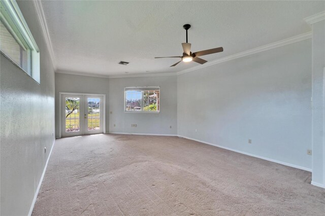 spare room with ceiling fan, light carpet, ornamental molding, and french doors