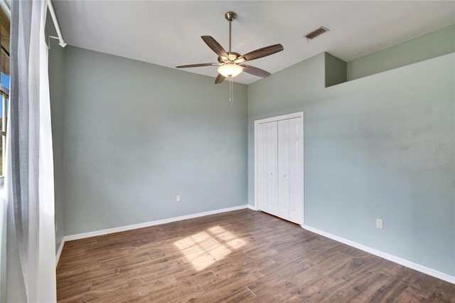 unfurnished bedroom featuring a closet, ceiling fan, and dark hardwood / wood-style flooring