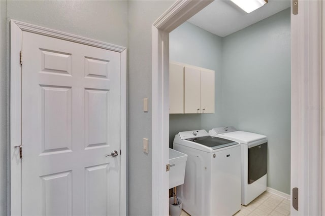 washroom with washer and clothes dryer and cabinets