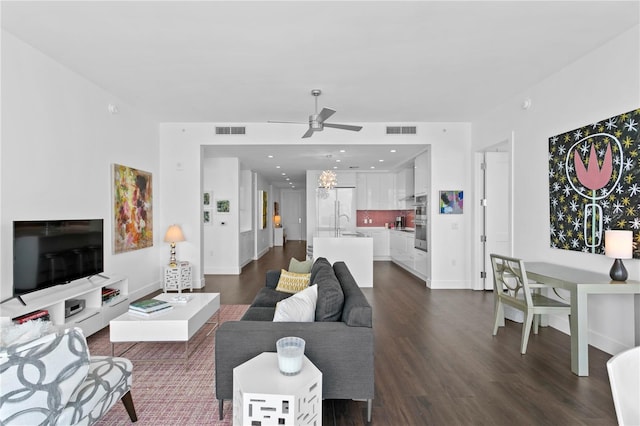 living room featuring ceiling fan, sink, and dark hardwood / wood-style flooring