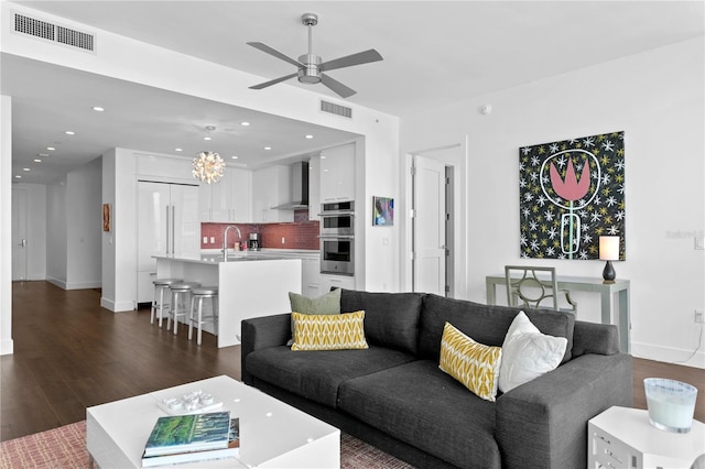 living room with ceiling fan, dark hardwood / wood-style flooring, and sink