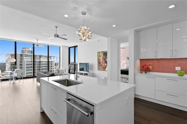 kitchen featuring dishwasher, white cabinetry, sink, backsplash, and hanging light fixtures