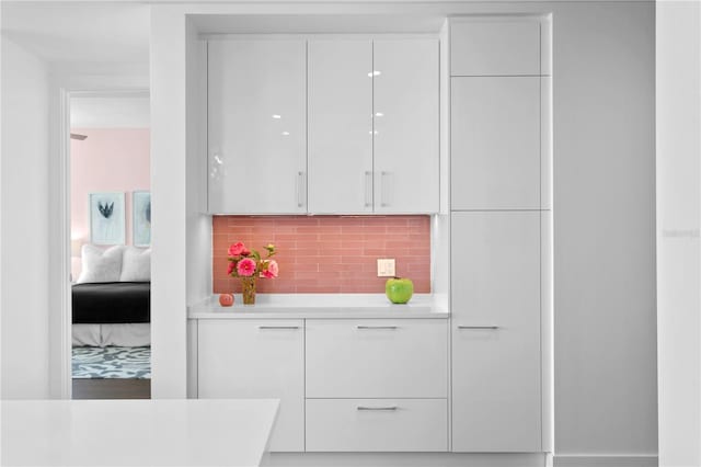 bar featuring white cabinets and backsplash