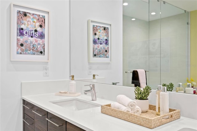 bathroom featuring a shower with door and vanity