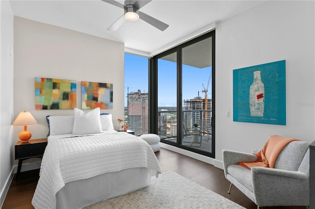 bedroom featuring ceiling fan, multiple windows, access to outside, and floor to ceiling windows