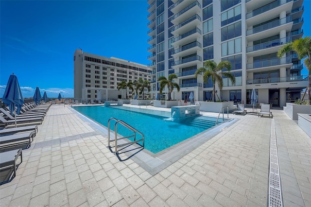 view of pool featuring pool water feature and a patio