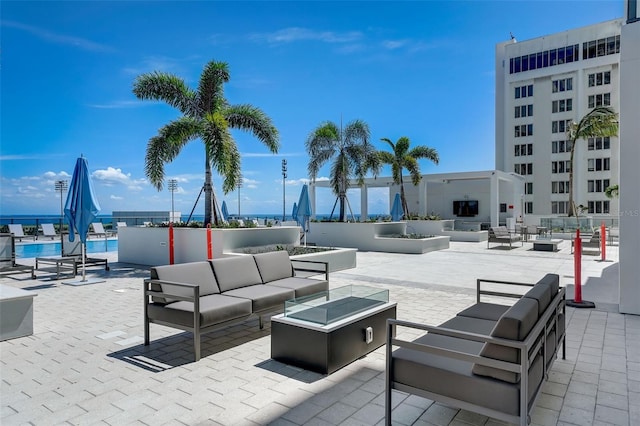 view of patio / terrace featuring a water view and an outdoor living space with a fire pit