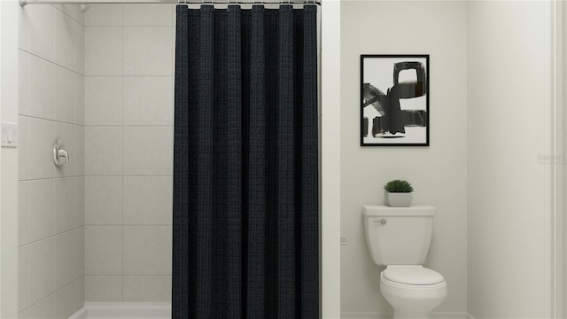 bathroom featuring toilet and curtained shower