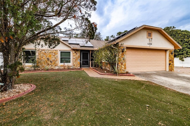 single story home with an attached garage, concrete driveway, stucco siding, roof mounted solar panels, and a front yard