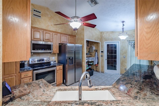 kitchen with ceiling fan, stainless steel appliances, decorative light fixtures, lofted ceiling, and sink