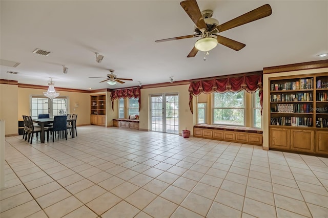 unfurnished living room featuring ceiling fan, light tile patterned floors, crown molding, and built in features